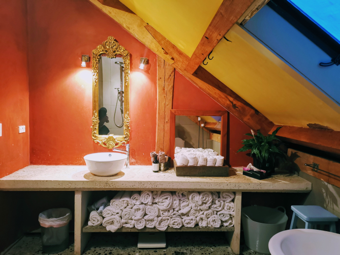 Photo of property: share the gorgeous industrial bathroom with its rainfall shower and white concrete heated floors featuring an antique claw bath